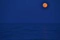 The moon rising over the horizon of the Mediterranean Sea. Photo taken from the shore of BenicÃÂ ssim beach Royalty Free Stock Photo